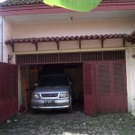 garasi dengan lantai batu dan pintu kayu