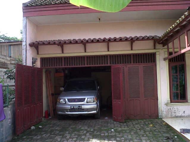 garasi dengan lantai batu dan pintu kayu